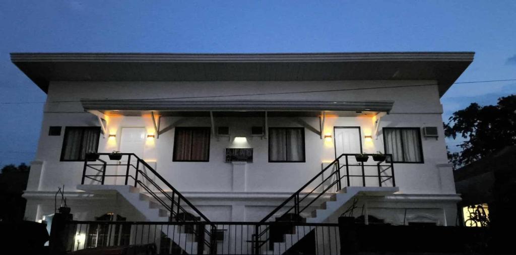 a white house with stairs in front of it at AMS Apartment in Butuan