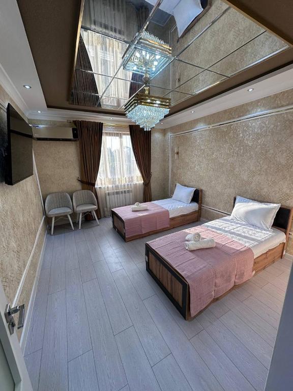 a large room with two beds and a window at Heart of Samarkand, main center in Samarkand