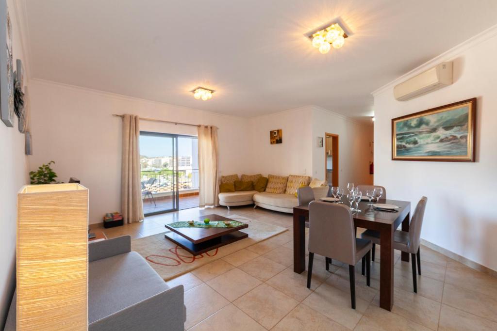 a living room with a table and a couch at Palmeiras Paz Apartment in Lagos
