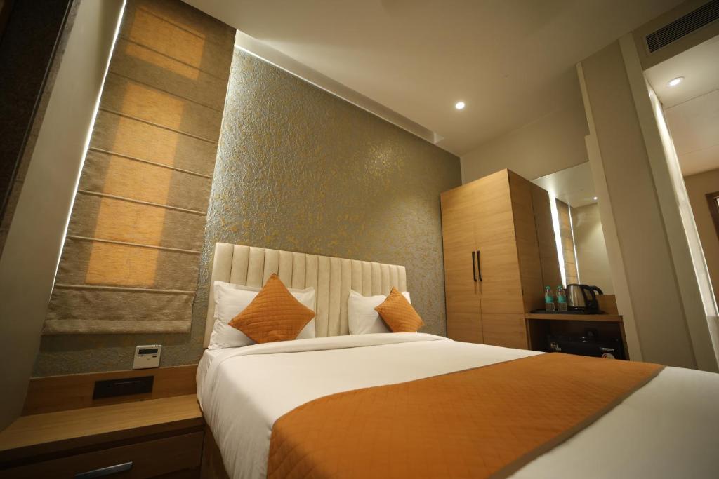 a bedroom with a large bed with orange pillows at Elight Inn Hotel in Jaipur