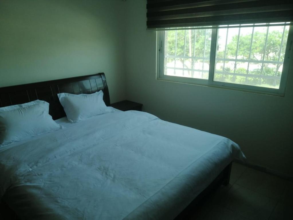 a bedroom with a large white bed with a window at ميرا للشقق المفروشة Mera Apartment in Aqaba
