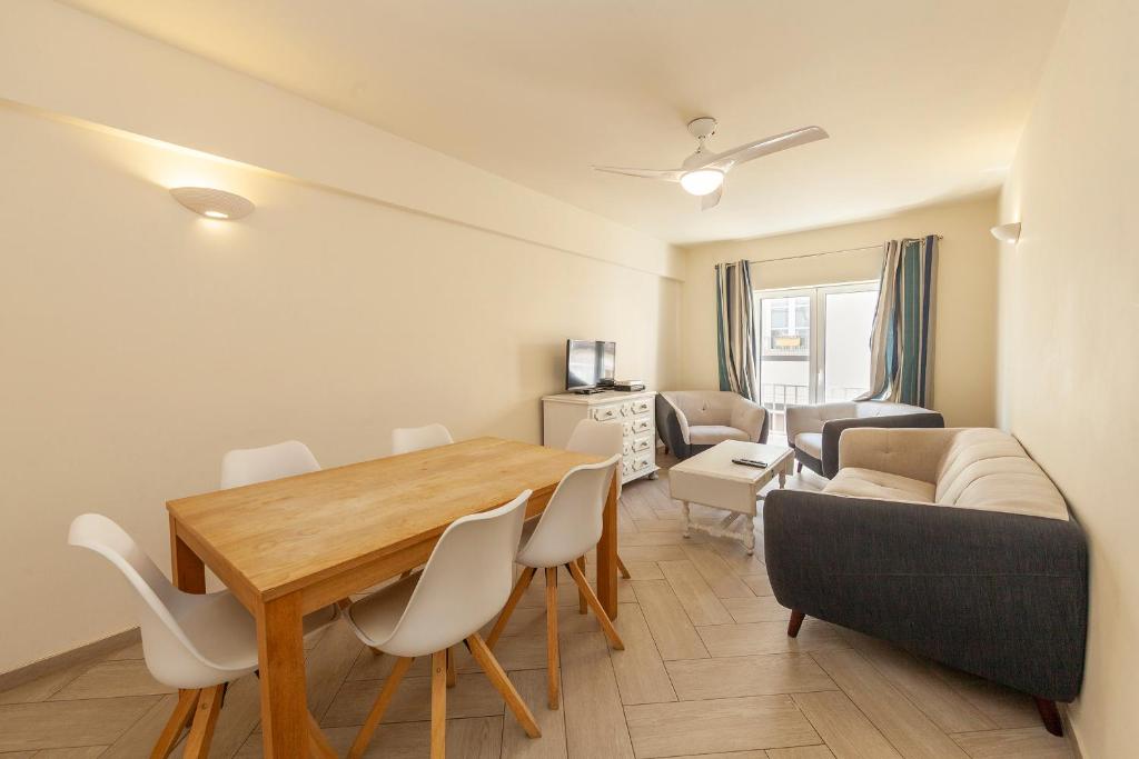 a living room with a dining room table and a couch at Lagos Center Apartment in Lagos