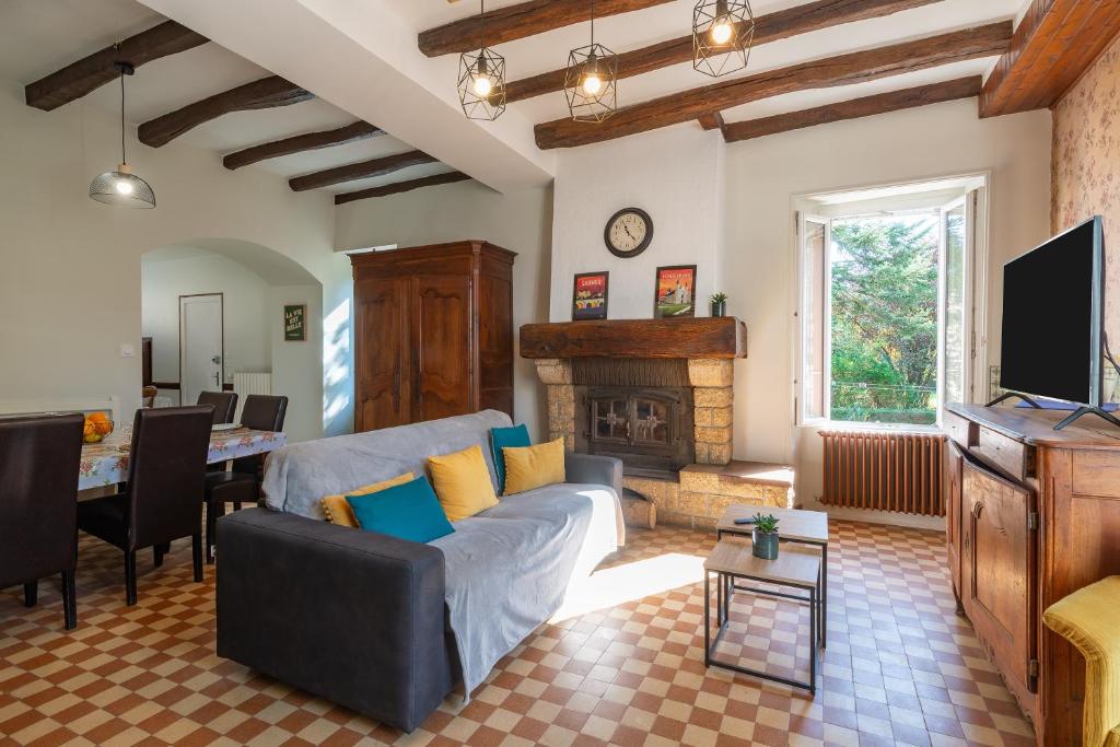 a living room with a couch and a fireplace at La Maison du Bonheur - Grand Jardin in Coron