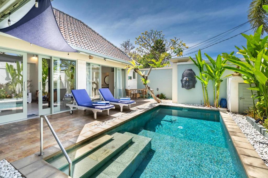 a villa with a swimming pool and a house at Villa Waterlily A Sanur in Sanur
