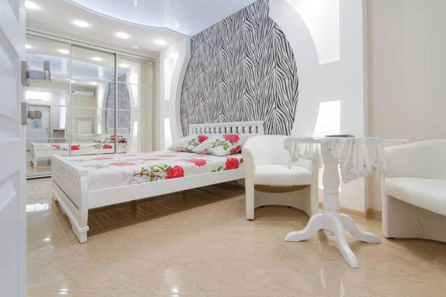 a white bedroom with a bed and a glass table at Apartment on Sadovaya in Odesa