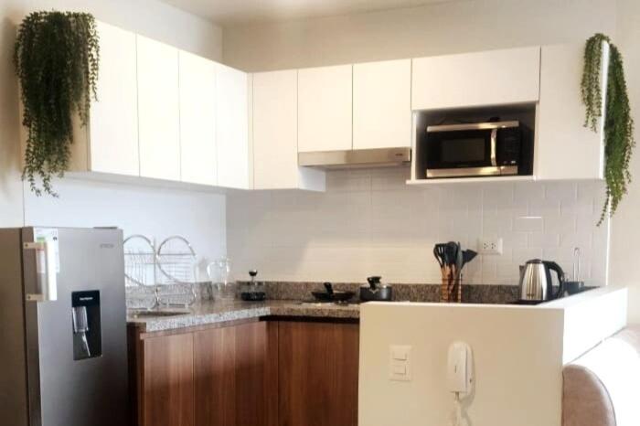 a kitchen with white cabinets and a stainless steel refrigerator at Depa UMBRA, one block from Rebagliati Hospital in Lima