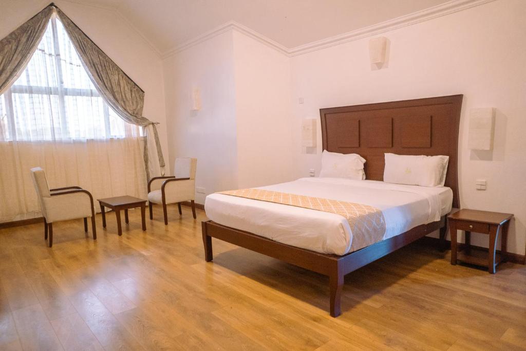 a bedroom with a large bed and a large window at Hidden Hills Thika Greens in Thika