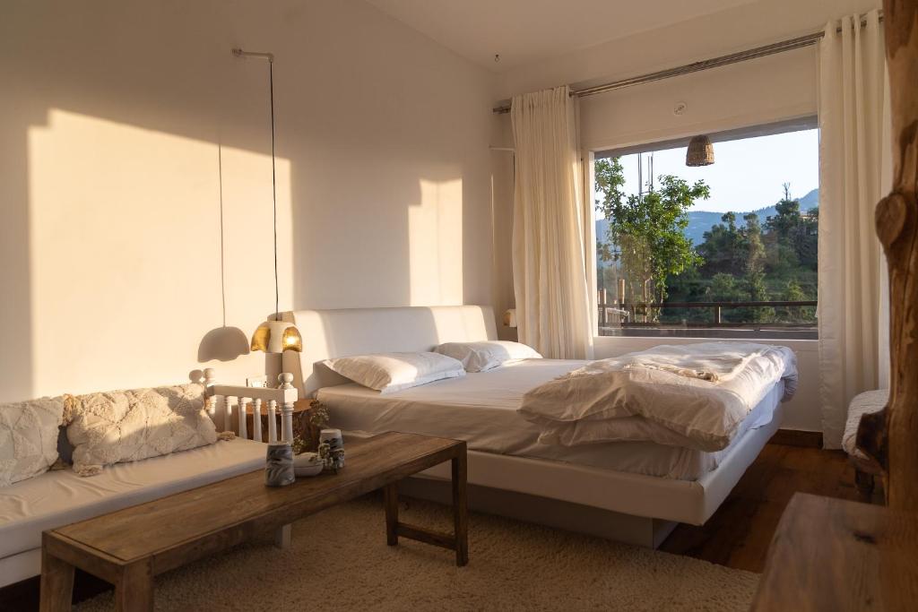 a bedroom with a bed and a couch and a window at Ecstacy bathtub rooms and cafe - Homestay in mukteshwar in Mukteswar