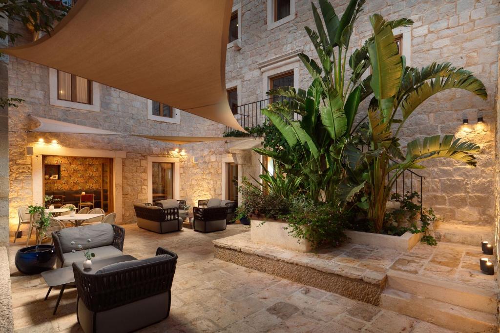 een terras met meubilair en een plant voor een gebouw bij Central Heritage Hotel in Split