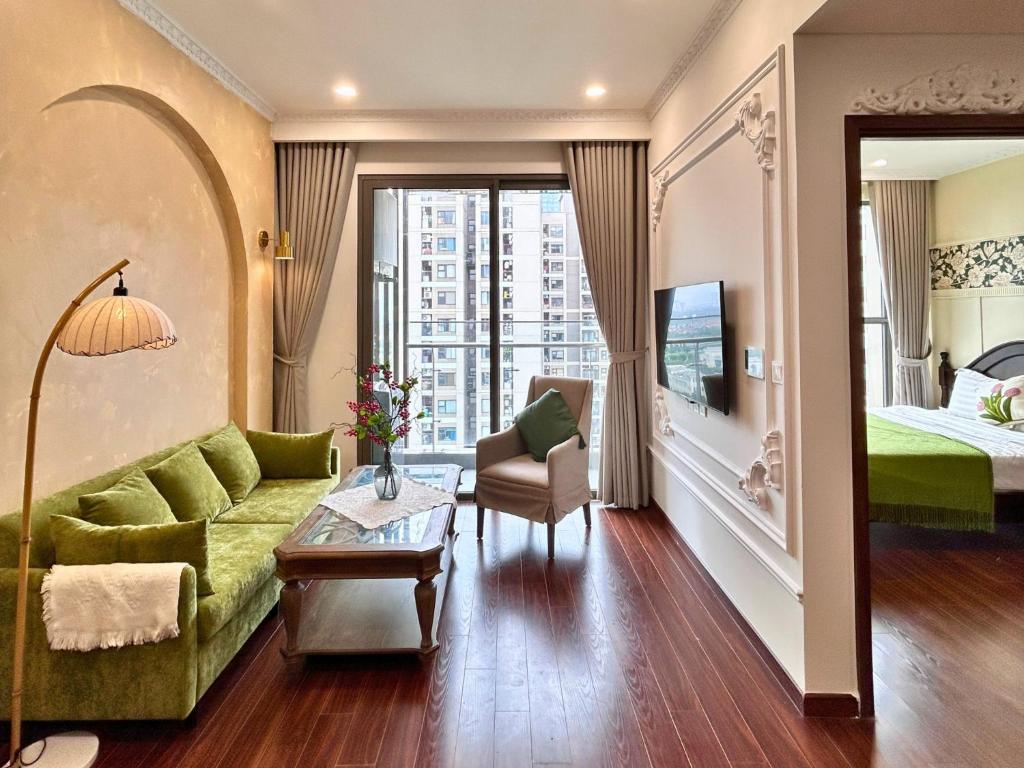 un salon avec un canapé vert et un lit dans l'établissement Amber Apt -Masteri WF -Ocean Park, à Hanoï
