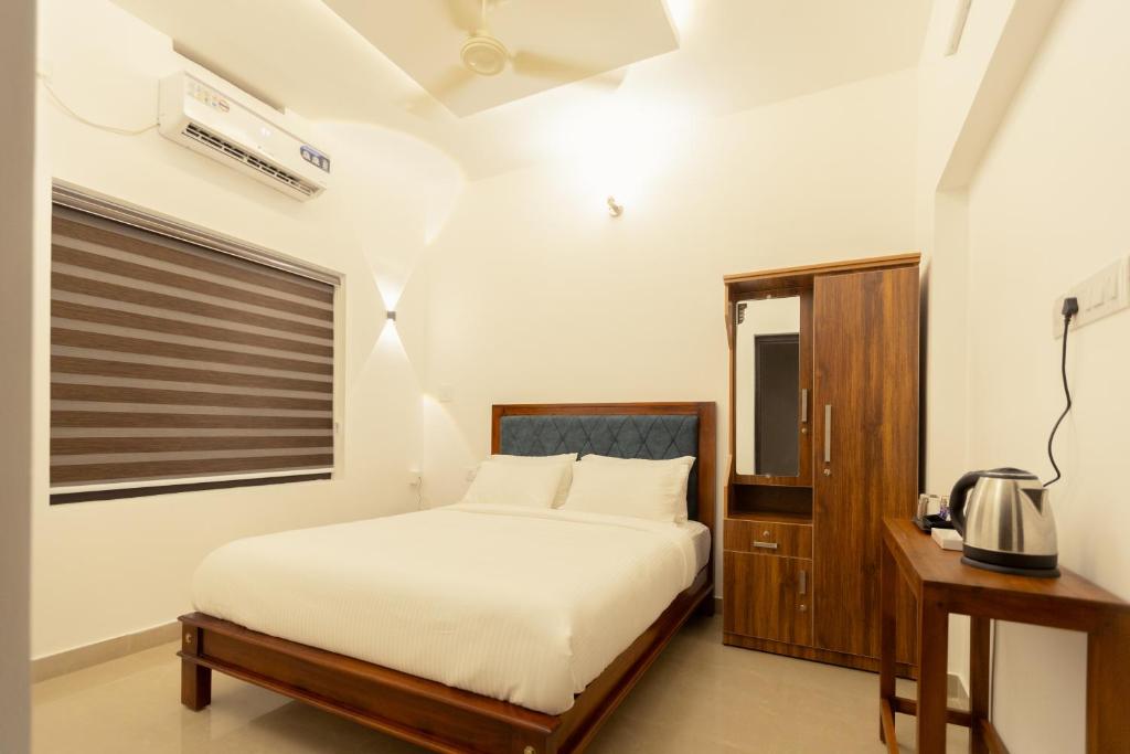 a bedroom with a white bed and a window at Greens Residency in Tripunnittara