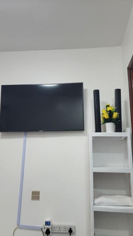 Elle comprend une télévision à écran plat installée au-dessus d'un mur. dans l'établissement Jakima studios Ruaka, à Ruaka