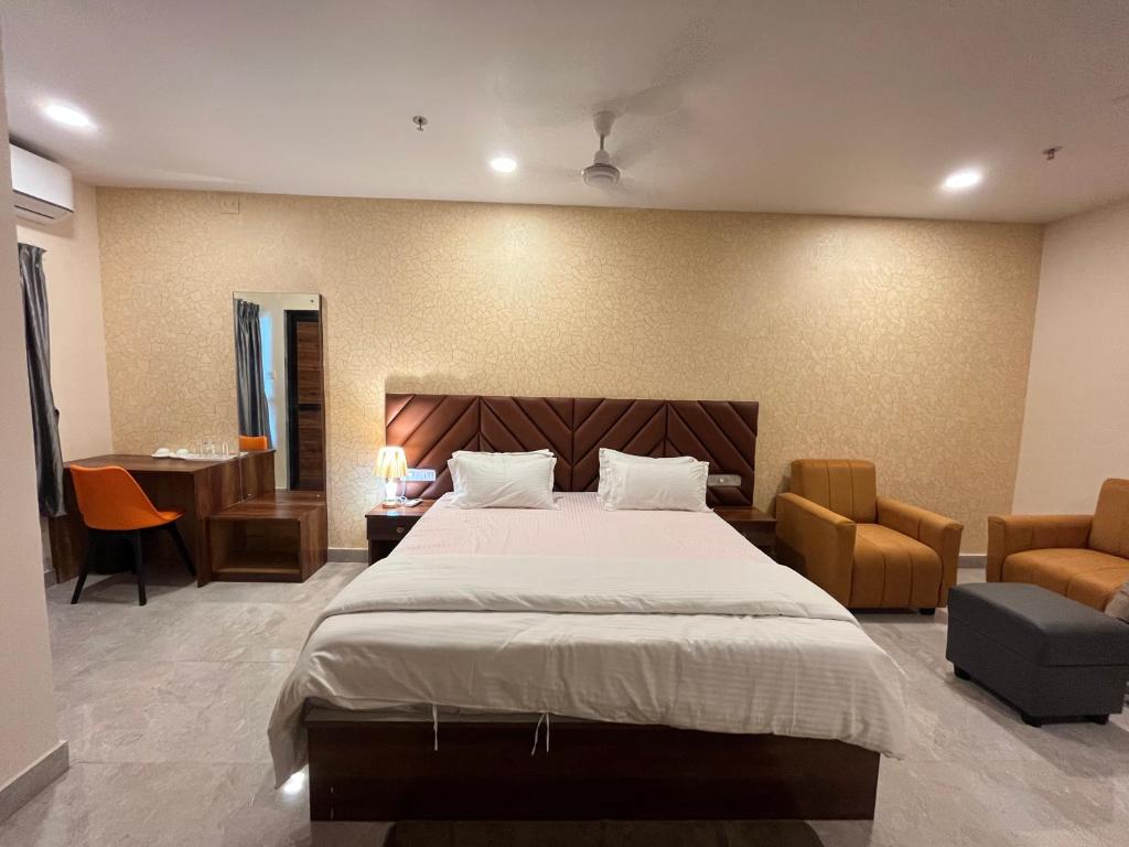 a bedroom with a large bed and a desk at Anjana Resort and Convention in Bhubaneshwar