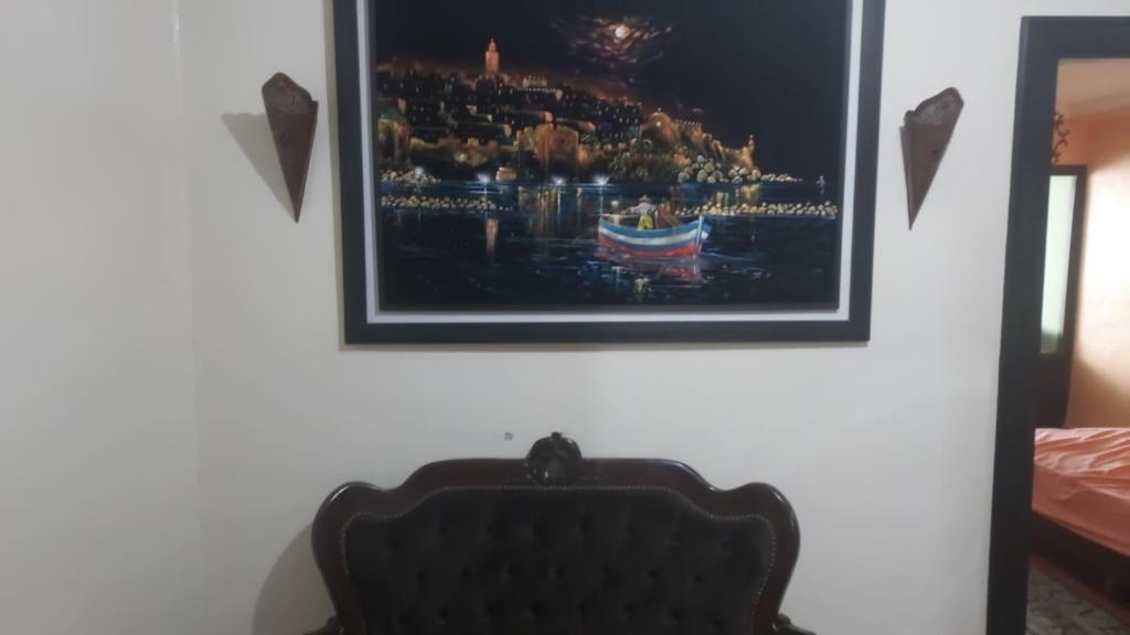 ein Bild an einer Wand mit einem Stuhl in einem Raum in der Unterkunft La gare agdal in Rabat