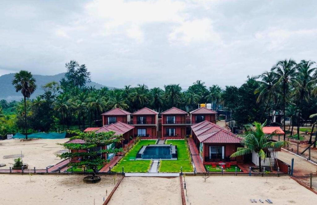 an aerial view of a house with a swimming pool at Shivani Sunset Bay Beach Resort in Māvalli