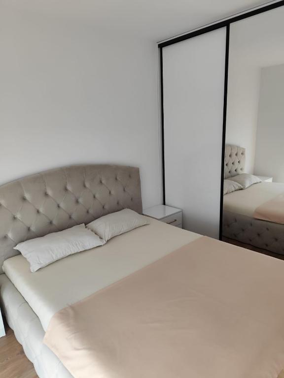 Un dormitorio con una gran cama blanca y un espejo. en LCB Apartments Suceava Universitate A96, en Suceava