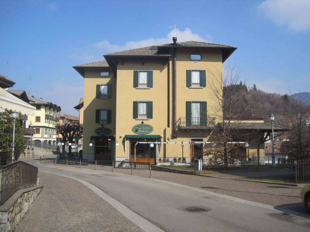 a yellow building on the side of a road at Hotel Residence Moderno in Selvino