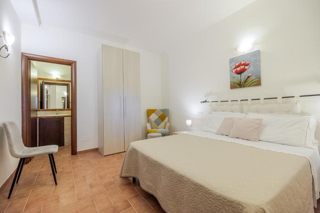 une chambre avec un grand lit blanc et une chaise dans l'établissement PODERE BAIOCCO TENUTA, à Città della Pieve 74 autres photos