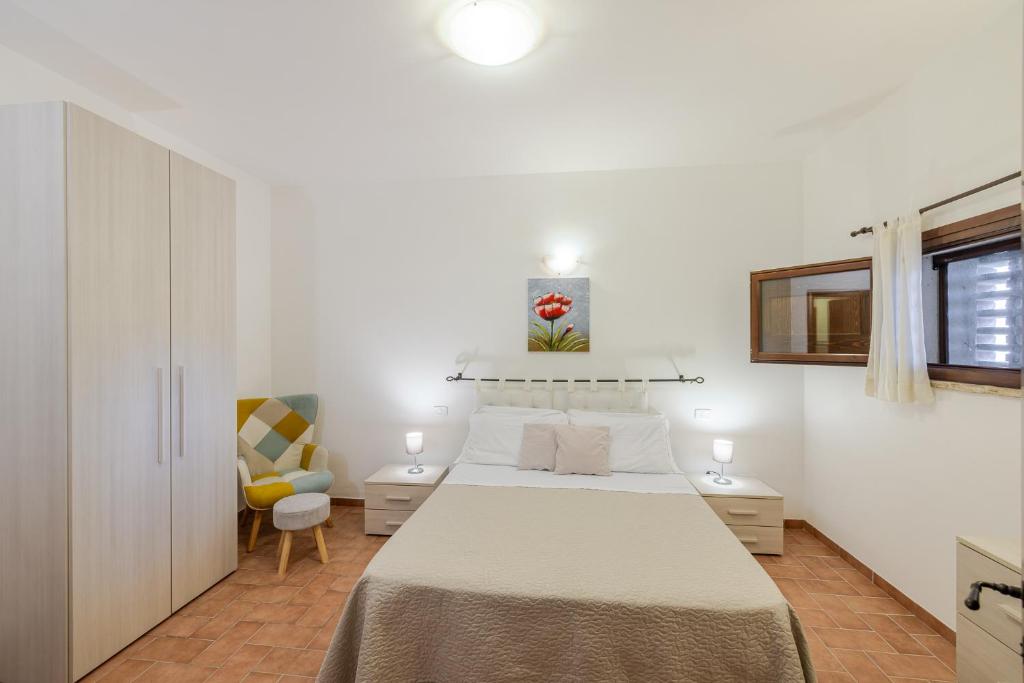 une chambre blanche avec un lit et une chaise dans l'établissement PODERE BAIOCCO TENUTA, à Città della Pieve