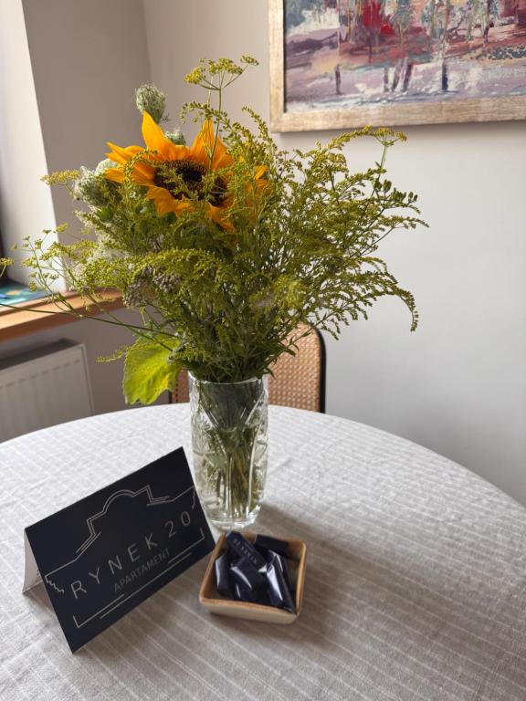 a vase of flowers sitting on a table with a card at Rynek 20 in Krosno