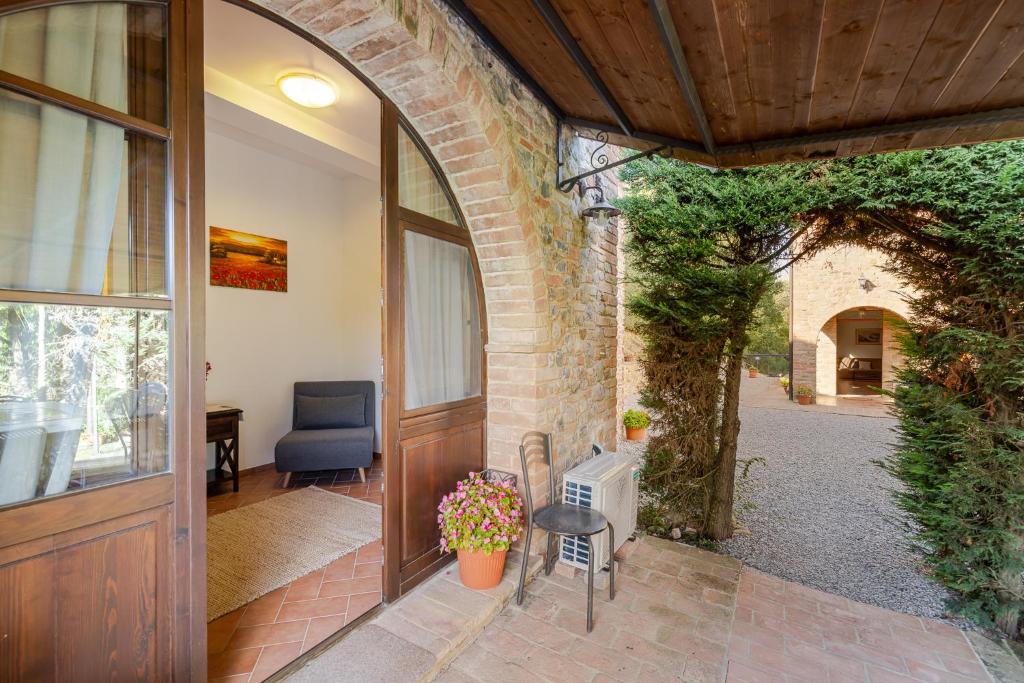 une entrée de maison avec une porte, une table et des chaises dans l'établissement PODERE BAIOCCO TENUTA, à Città della Pieve