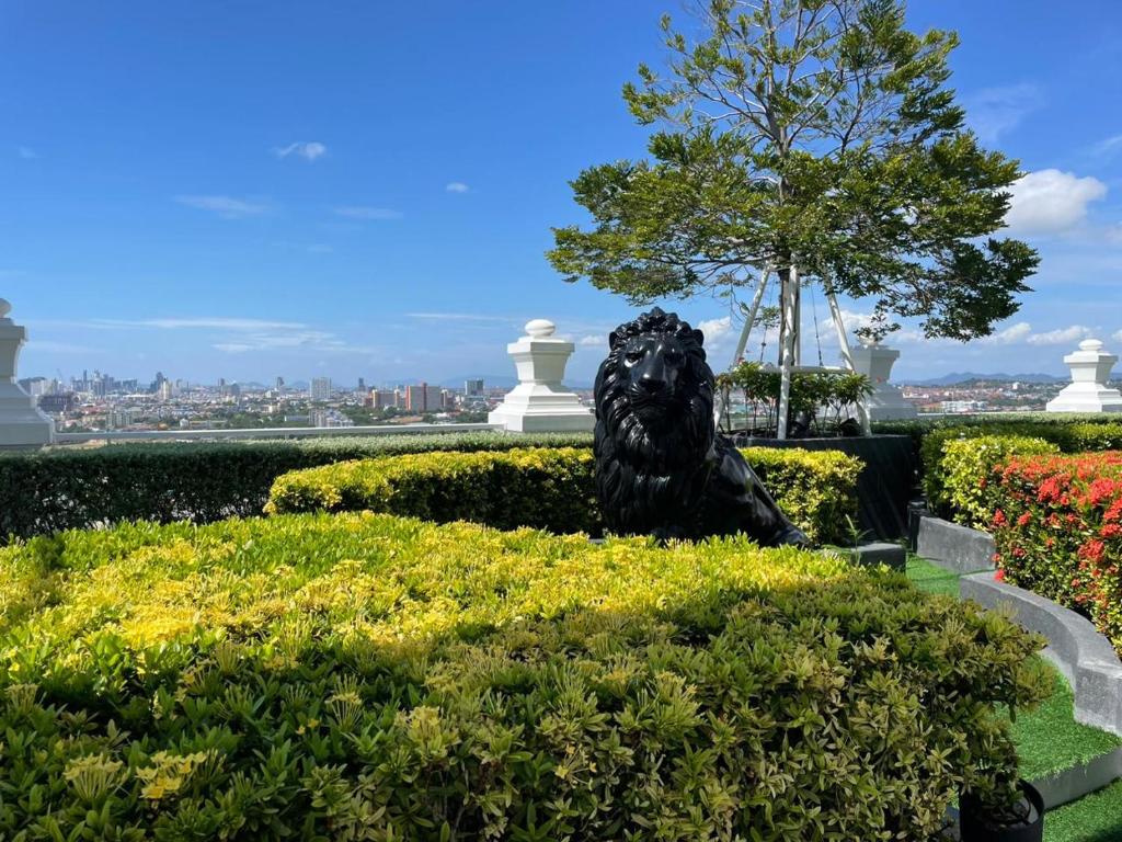 une statue d'un lion assise dans un jardin dans l'établissement The Empire Tower Pattaya, à Jomtien Beach