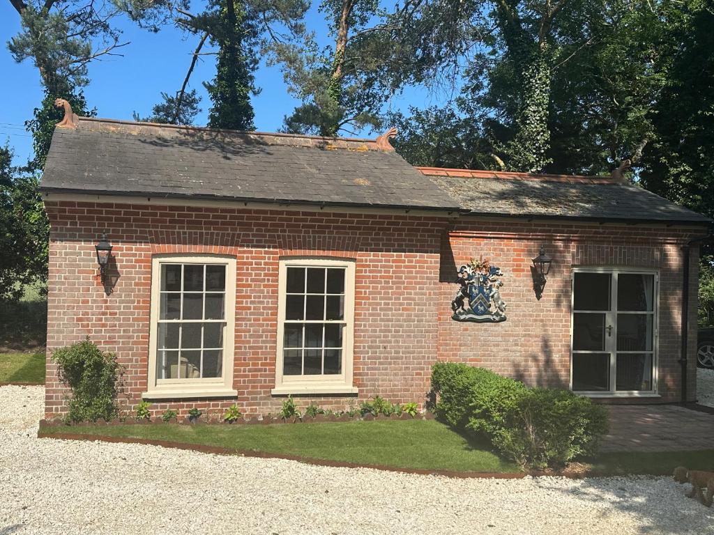 a red brick house with two windows on a yard at The Gatehouse in Trimingham