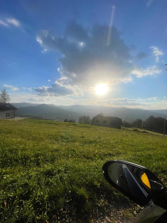 una vista dal finestrino di un'auto di un campo con il sole di Dom nad Wisłą - pobyty rodzinne, grupowe, terapie a Wisła