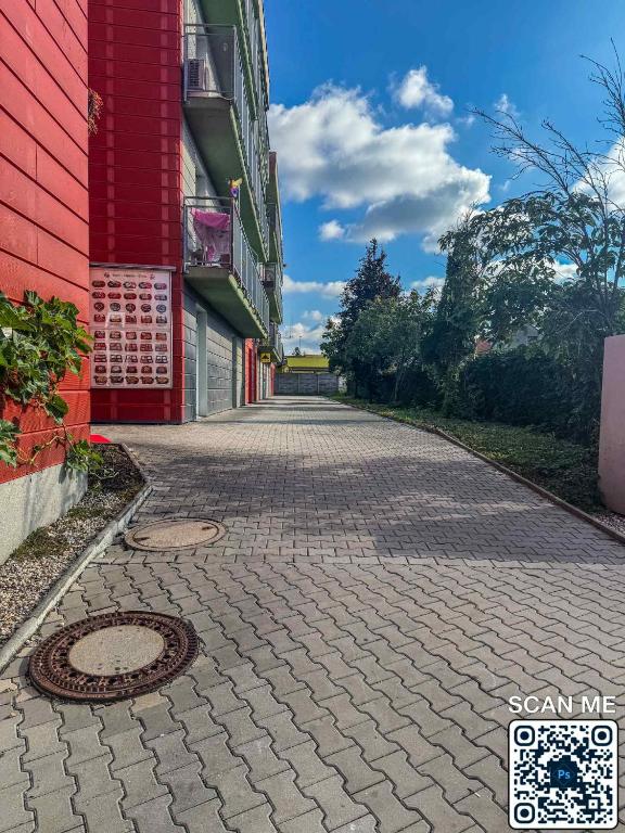 a cobblestone street next to a red building at YCZ Praha in Prague