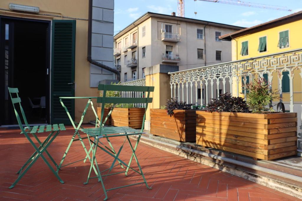 a green chair and a chair on a balcony at Terrazza Sonnino in Pisa
