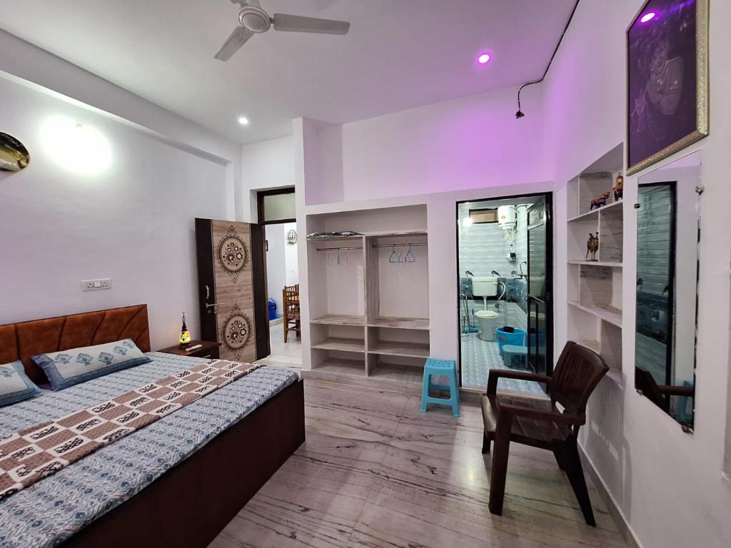 Un dormitorio con una cama y una silla y una ventana. en Tara Home Stay, en Udaipur