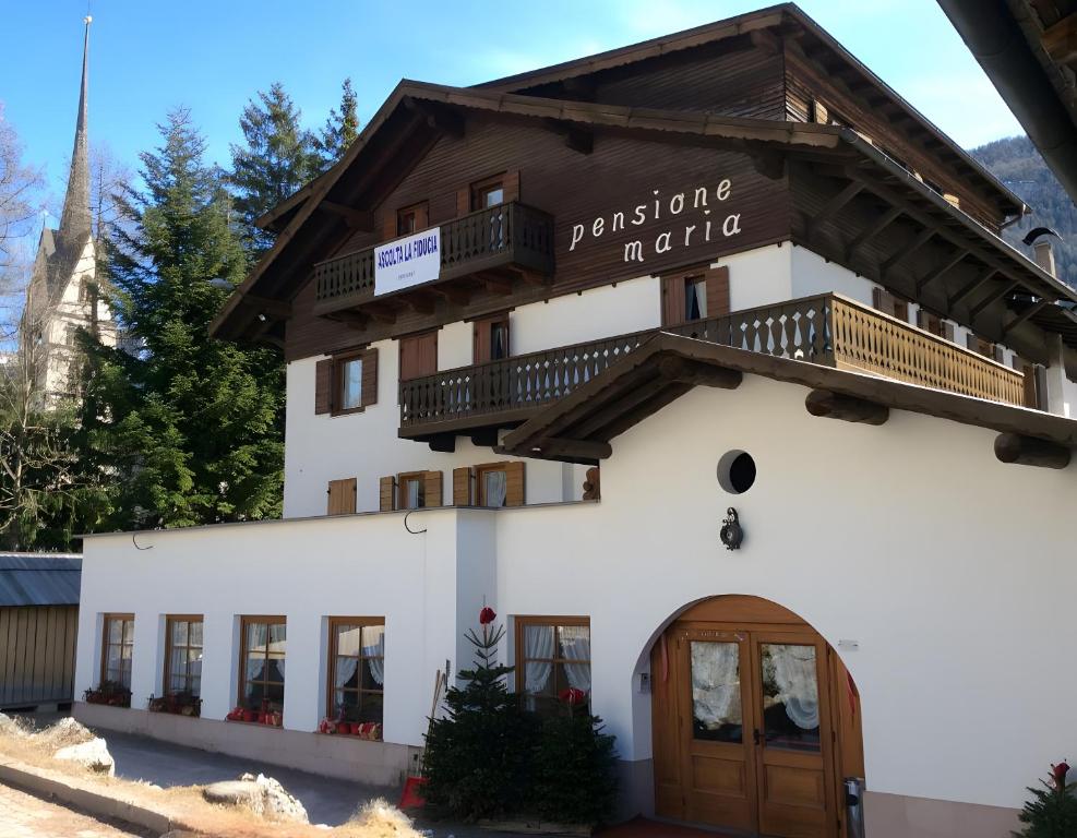 a building with a sign for the pension institute at Locanda Maria in Vigo di Fassa