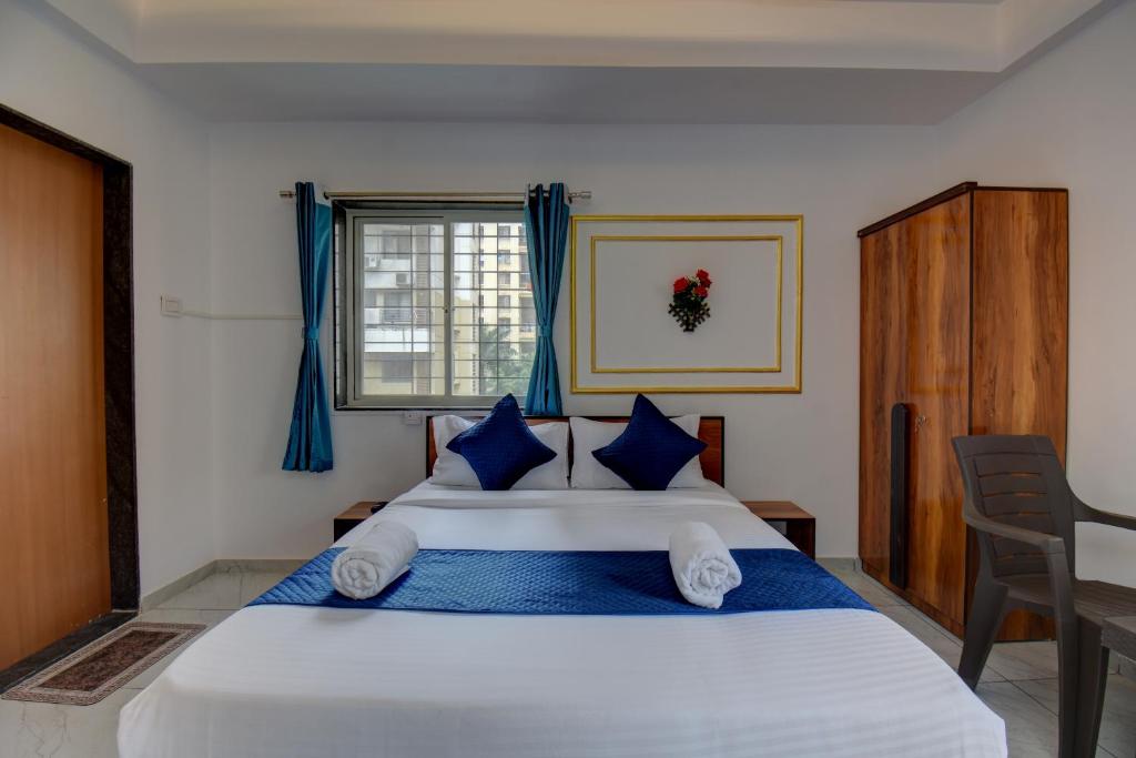 a bedroom with a large white bed with blue pillows at Quite Room in pune city in Méribel Village