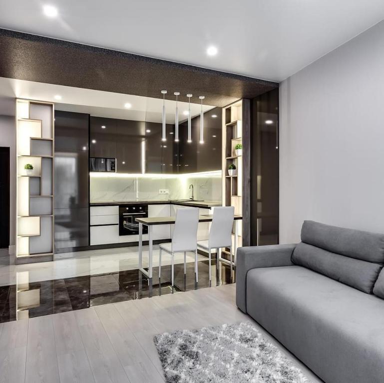 a kitchen and living room with a couch and a table at Новобудова Трускавецька, Автовокзал, Шувар,Кінг Крос in Lviv