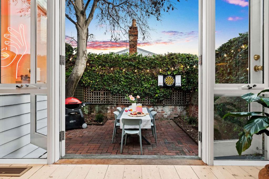 a table and chairs on a patio outside a door at Richmond Royale walk to the MCG Swan St & Bridge Road in Melbourne