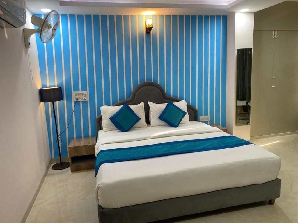 a bedroom with a large bed with blue stripes at Immense Residency in Faridabad