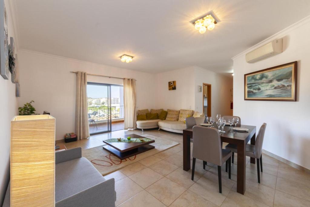 a living room with a table and a dining room at A68 - Palmeiras Paz Apartment in Lagos