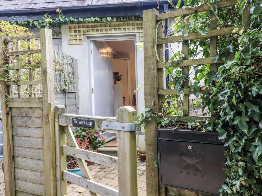 a wooden fence with a gate and a door at The Workshop in Tavistock