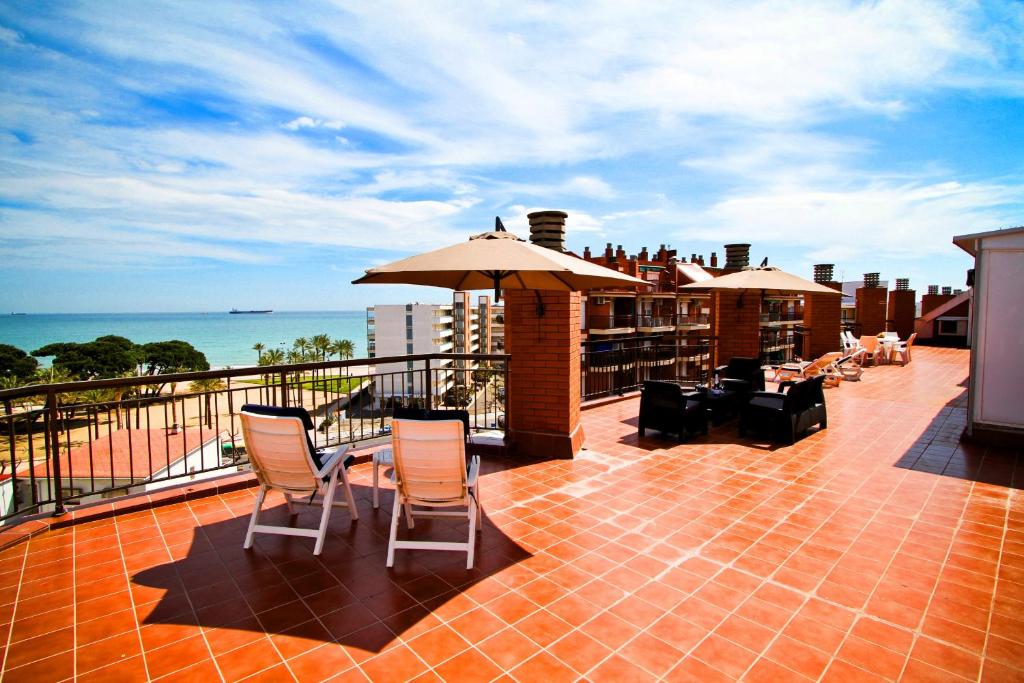 a balcony with a table and chairs and an umbrella at TECAVI II Atic Planetcostadorada in La Pineda