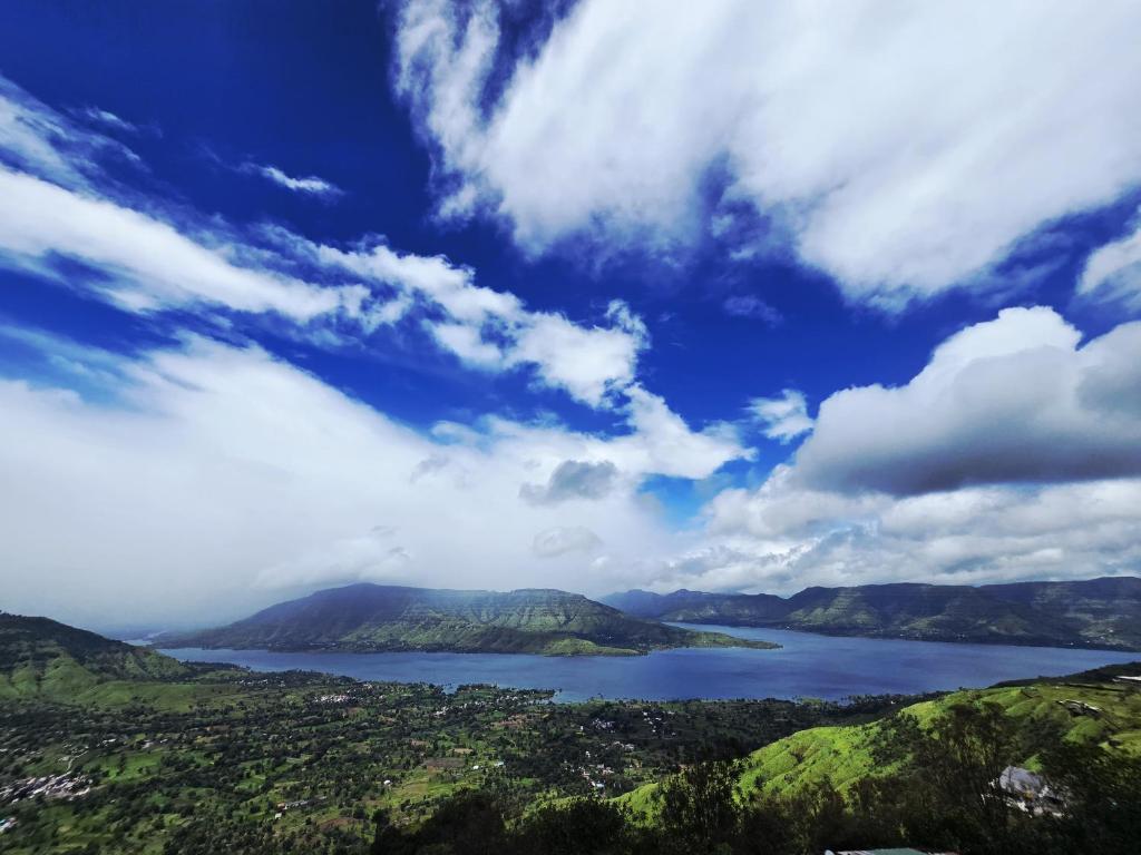 a view of a large body of water with mountains at Marine Villa - Valley View l Swimming pool l AC in Panchgani