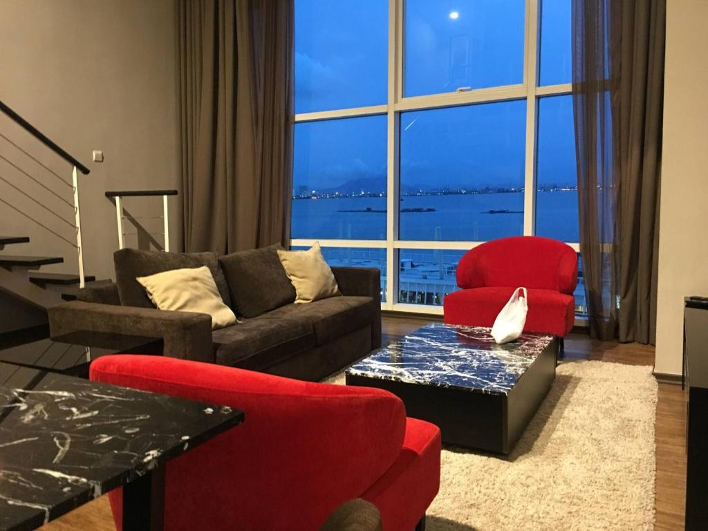 a living room with a couch and a red chair at Urbano Luxury Homestay at Maritime in George Town