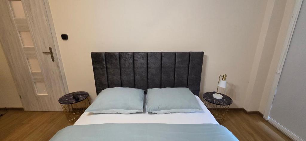a bed with a black headboard in a room at Mieszkanie, Blisko Stadionu Tarczyński Arena, Blisko Hala Orbita in Wrocław