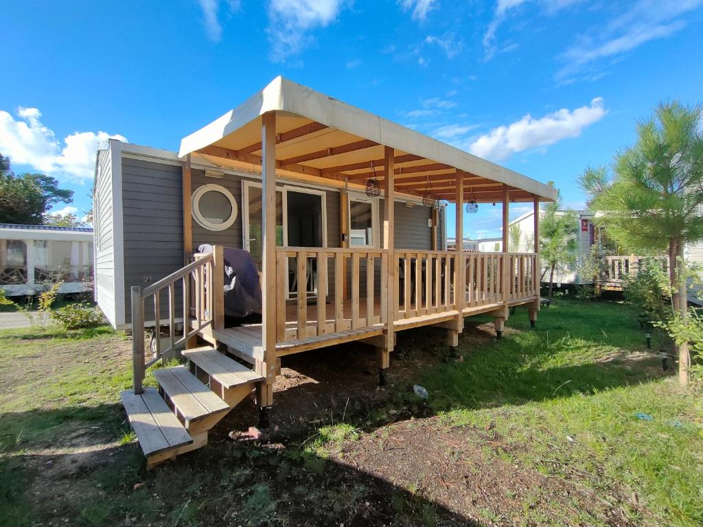 a mobile home with a porch and stairs to it at Chez Seb et Sarah - Bungalow Paisible aux Viviers in Lège-Cap-Ferret
