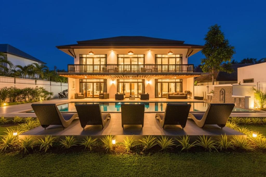 a villa with a swimming pool at night at Eden Villa A Tropical Paradise Pool Villa in Rawai Beach