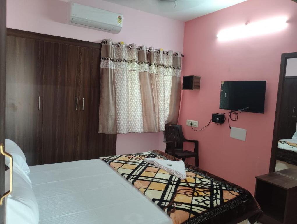 a hotel room with a bed and a tv and a bedroom at RK Home in Madurai