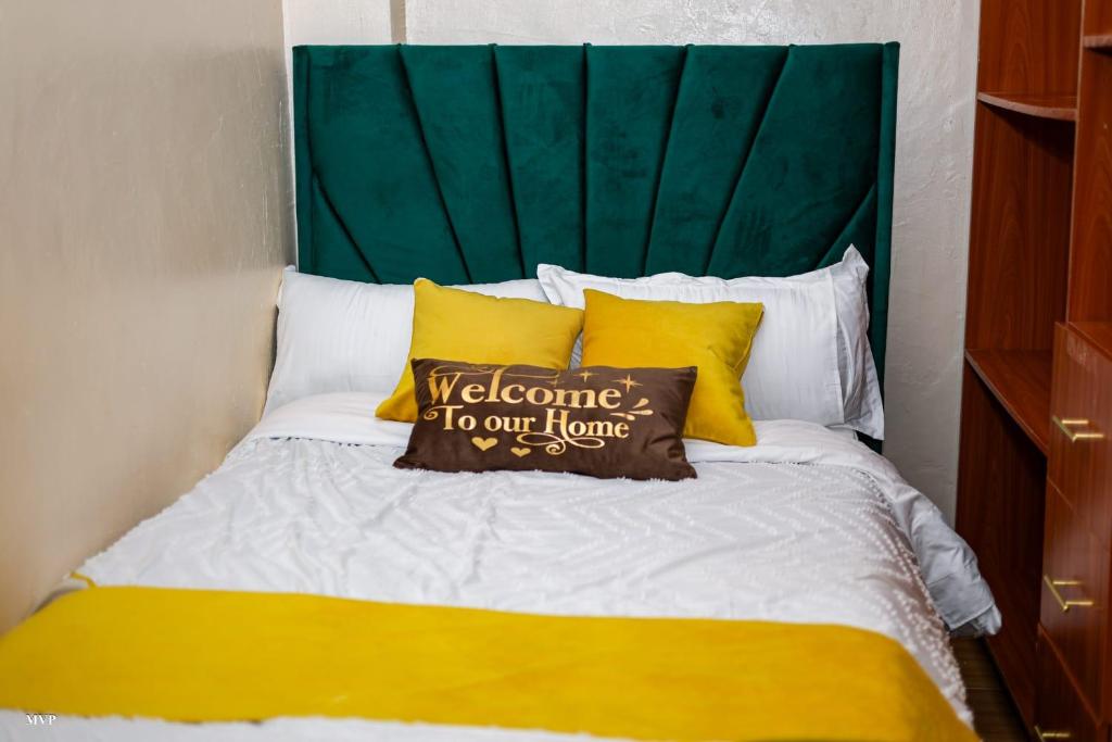 a bed with a pillow with a welcome to our home at Amani stayss in Isiolo