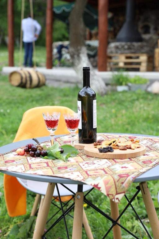 a bottle of wine sitting on a table with wine glasses at Toneh Villa in Lernarot