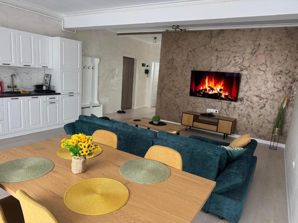 a living room with a couch and a table with a fireplace at RakanStudioApart in Timişoara