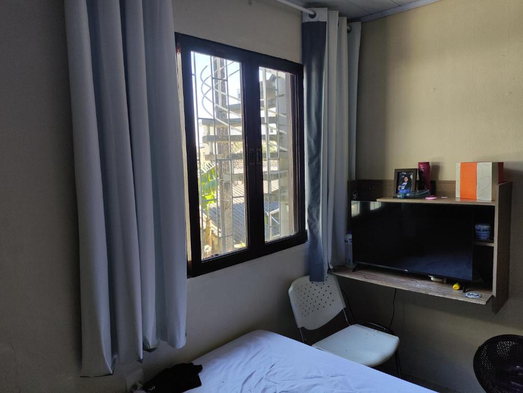 a bedroom with a bed and a window at Ferreira hostel in Florianópolis