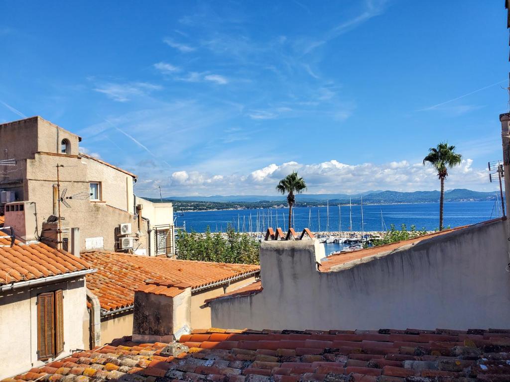 a view of the ocean from the roofs of buildings at Appartement lumineux à deux pas du port, avec terrasse in La Ciotat